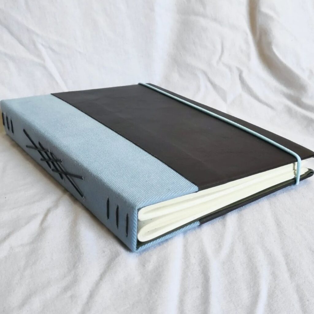 Um caderno com capa azul e preta